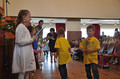 Die &auml;lteren Schulkinder &uuml;bergeben ein Bl&uuml;mchen